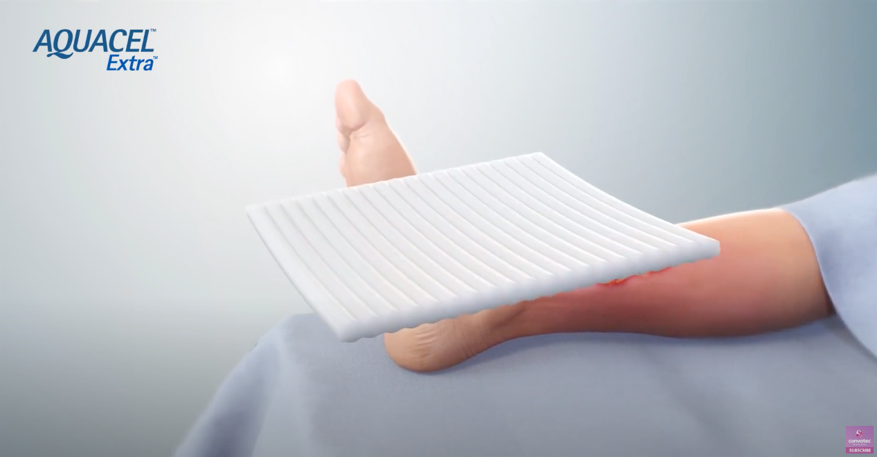 a hand holding a wound dressing