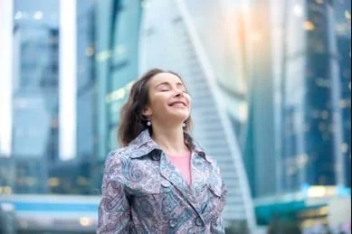 Una mujer de pie frente a un edificio de la ciudad.
