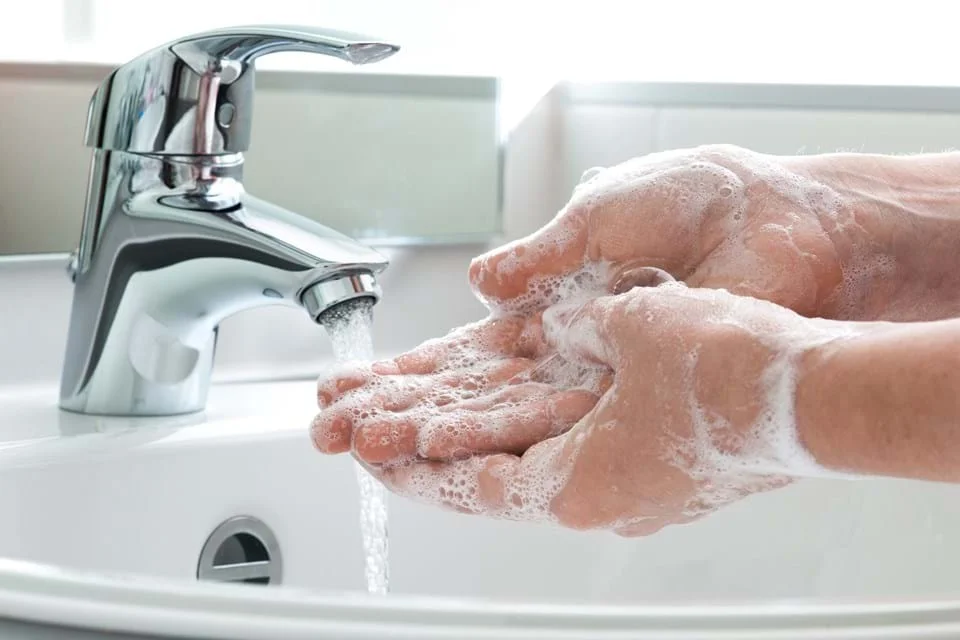 une personne qui se lave les mains dans un évier